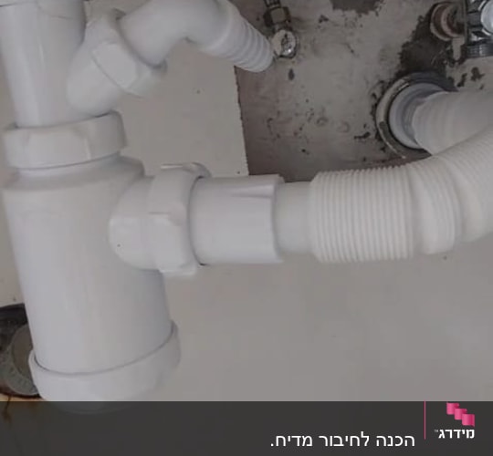 צנרת לבנה עם חיבורים מתחת לכיור